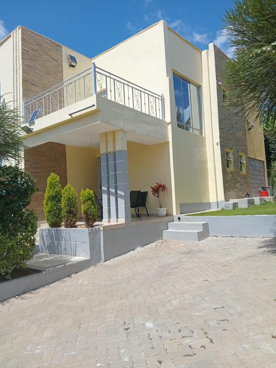 A modern mansionette with a balcony and landscaped entrance